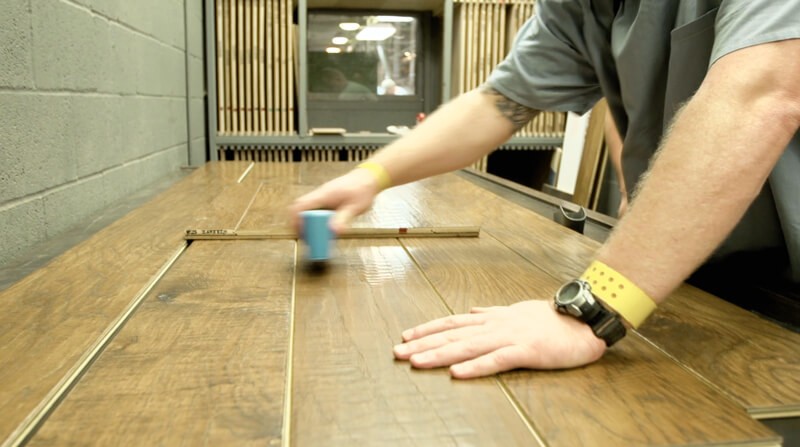 Hearthwood Floors - Inmate measuring wood, working on an order