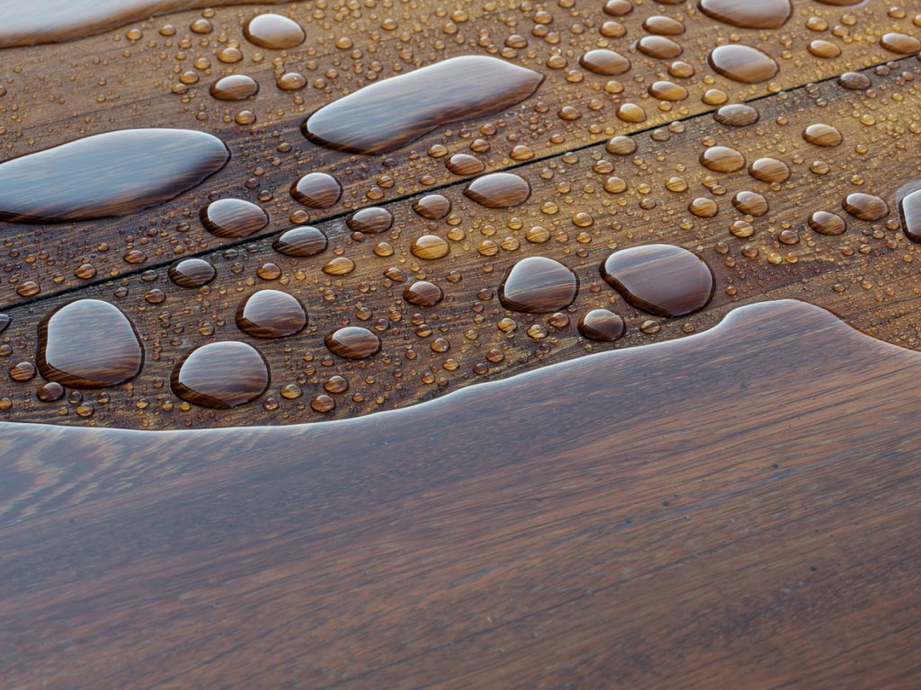 close up of water drops on a wood floor to show water resistant engineered hardwood
